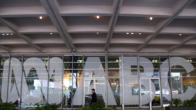 An employee walks past the logo of the ABC located at the main entrance to the ABC building located at Ultimo in Sydney. Picture: AAP