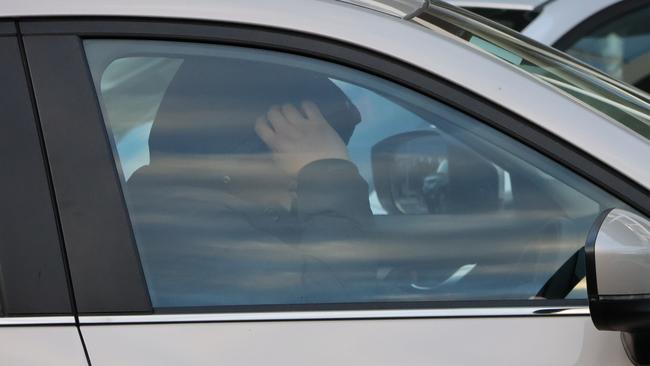 William Doherty attempts to hide his face while driving away from court after being sentenced. Picture: Blake Foden