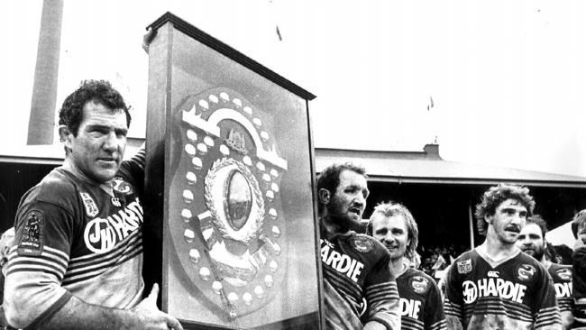 Mick Cronin and Ray Price holding the JJ Giltinan Shield with Peter Sterling &amp; Brett Kenny after winning the 1986 grand final. Picture: Peter Kurnik.