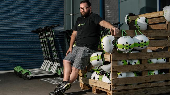 Lime’s regional operations manager Jeff Roberts with scooters and helmets at the warehouse on their final day of operation on Sunday. Picture: AAP / Morgan Sette