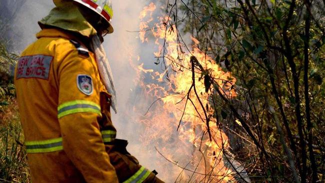 RFS crews worked to protect a house from fire after a vehicle fire spread to nearby paddocks. Picture: Jeremy Piper