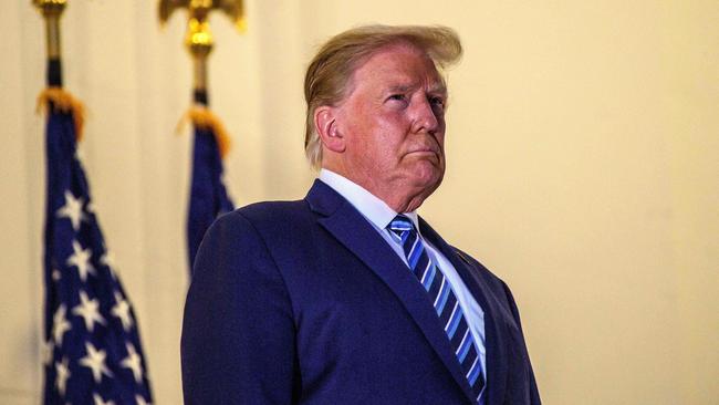 US President Donald Trump looks out from the Truman Balcony after returning to the White House from Walter Reed Medical Center, where he underwent treatment for Covid-19. Picture: AFP