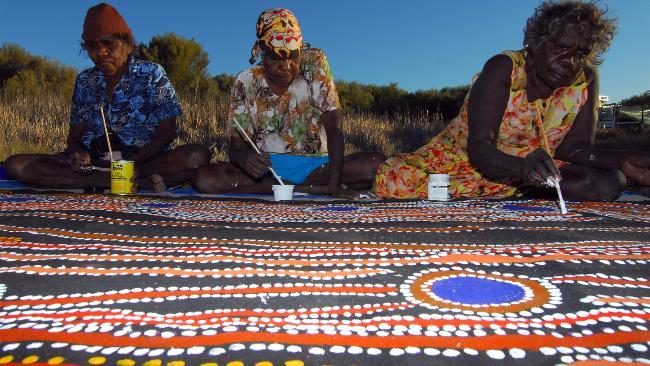 Martumili artists Rosie Williams, Dulcie Gibbs and Muni Rita Simpson working on <em>Minyipuru</em> (Seven Sisters). From the exhibition Yiwarra Kuju: The Canning Stock Route at the National Museum of Australia in Canberra. Picture: Tim Acker