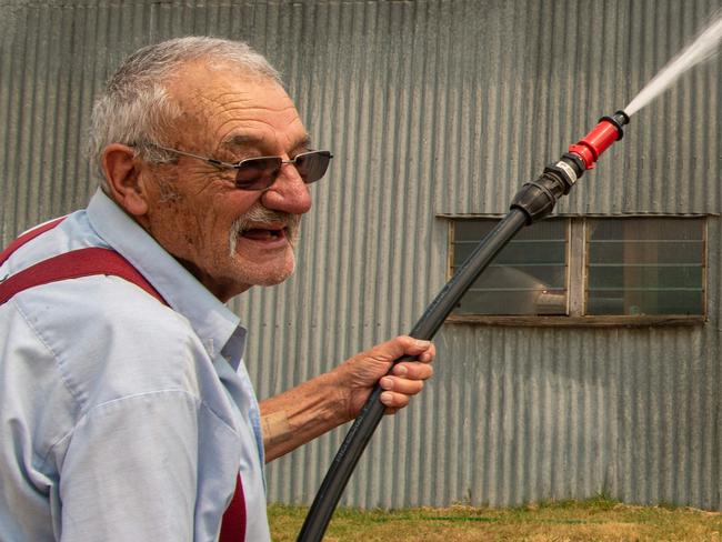 Ben Buckly, 83 in the farming town of Benambra runs through his bushfire defence response with his daughter Janelle, 46, ahead of tomorrows worsening weather.  Wetting gutters and trees.  Picture: Jason Edwards