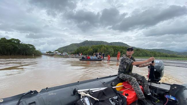 Royal Australian Navy personnel work with civilian emergency services to evacuate members of the public from Holloways Beach using a stretch of the Captain Cook Highway near the Barron River Bridge. Picture: Supplied