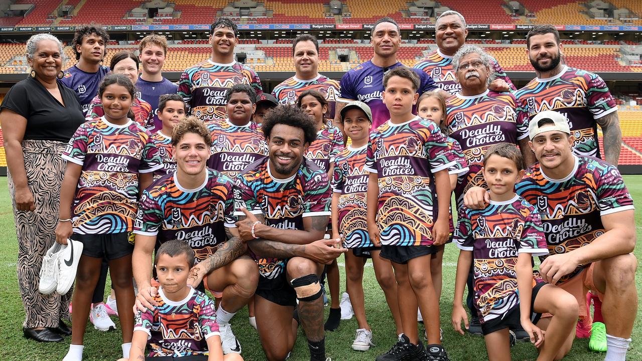 Broncos players Ezra Mam, Reece Walsh, Kotoni Staggs, Adam Reynolds and Selwyn Cobbo, along with former Broncos players Steven Renouf and Petero Civoniceva pose for a photo with a group of young Indigenous schoolchildren in the team’s Indigenous jersey. Picture: Getty Images