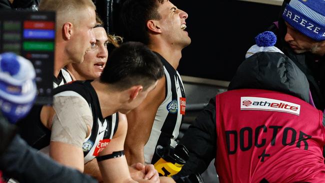 MELBOURNE, AUSTRALIA - JUNE 10: Nick Daicos of the Magpies is assessed by medical staff on the bench during the 2024 AFL Round 13 match between the Collingwood Magpies and the Melbourne Demons at The Melbourne Cricket Ground on June 10, 2024 in Melbourne, Australia. (Photo by Dylan Burns/AFL Photos via Getty Images)