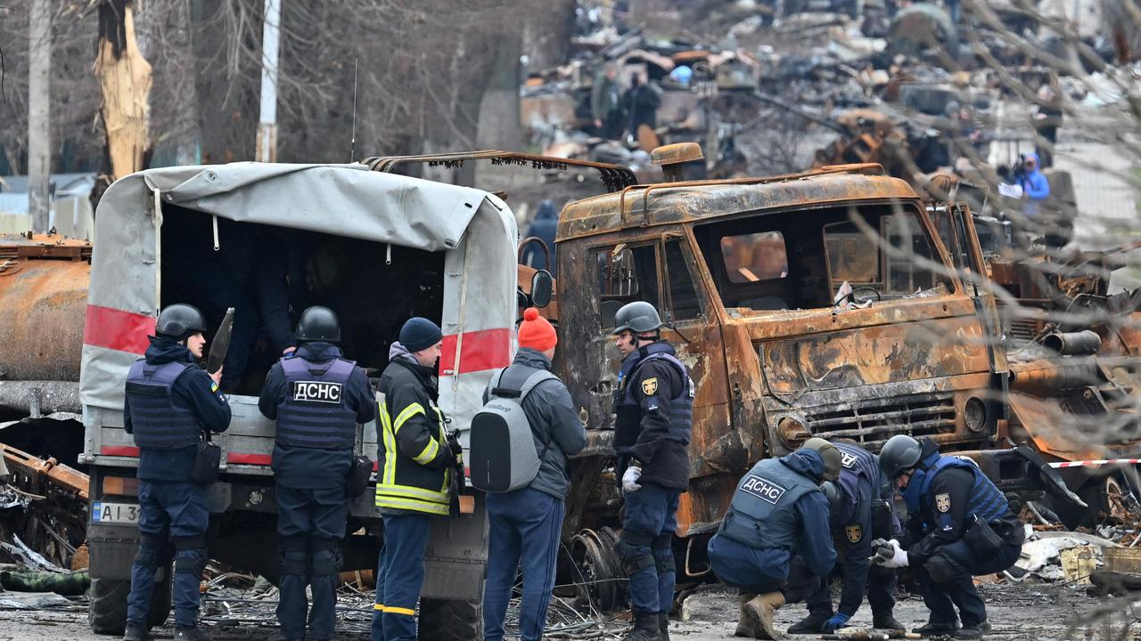 Field engineers of the State Emergency Service of Ukraine conduct mine clearing among destroyed vehicles on a street of Bucha. Picture: Genya SAVILOV / AFP