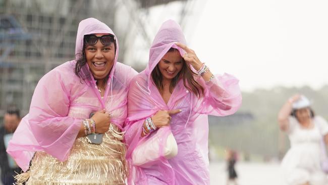 Taylor Swift fans duck for cover as a thunderstorm spreads over Sydney just hours before the pop star takes the stage.