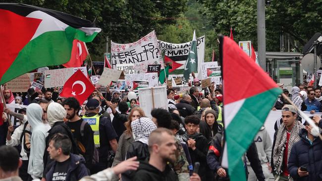 Supporters carried signs and flags as they marched through the city. Picture: NCA NewsWire / Valeriu Campan