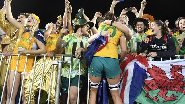 Alicia Quirk celebrates with a supporter after victory in the women’s rugby sevens. Picture: AFP Photo / John Macdougall