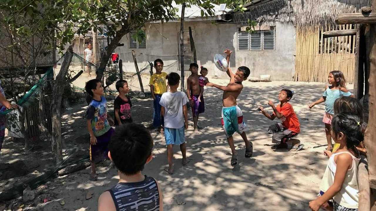 Rob Williams has given the gift of footballs donated by the Ipswich Jets Rugby League Club to kids around the world. Kids play with a football in their village on Cabuli Island, Palawan, The Philippines. Picture: Charisse Farr