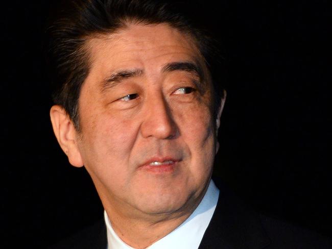 Japanese Prime Minister Shinzo Abe looks back after arriving at the Fairbairn defence establishment in Canberra on July 7, 2014. Defence ties are set to take centre stage when Australia plays host to Japanese Prime Minister Shinzo Abe this week, as the two countries look set to strengthen their relationship through annual leaders' meetings. AFP PHOTO / Saeed KHAN