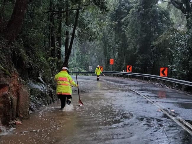 Copacabana Rural Fire Brigade used shovels and hands to unblock a drain on Cullens Rd, caused by a land slip. Picture: Copacabana Rural Fire Brigade