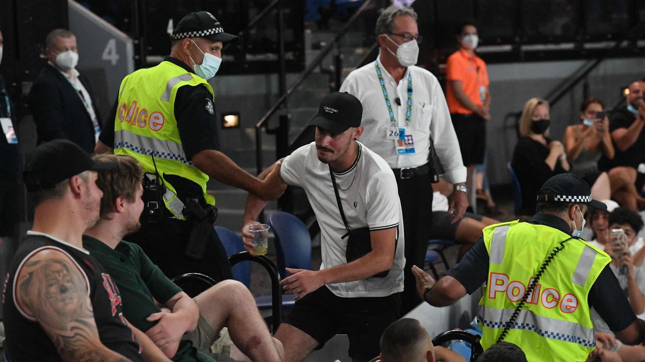 Police escort a fan from the arena as Italy's Matteo Berrettini defeats France's Gael Monfils. Picture: William West/AFP