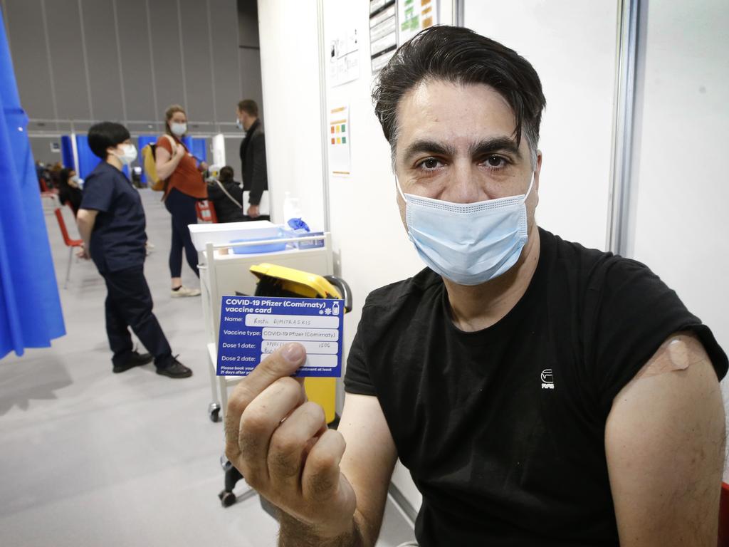 Kosta Dimitrakis 44, from Brighton shows his vaccination card after getting his Covid jab. Picture: David Caird