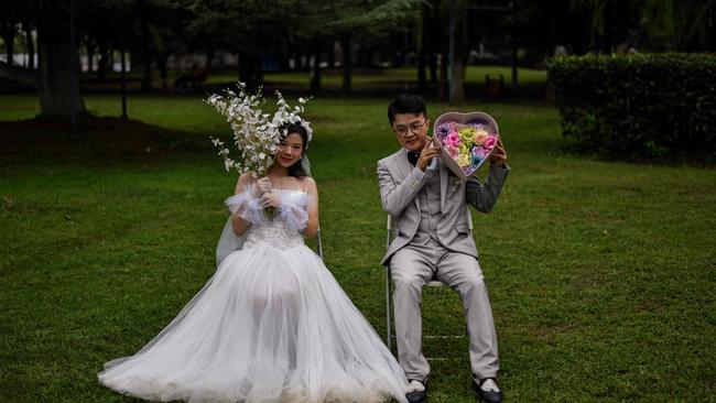 A couple pose for a wedding photographer in a park next to the Yangtze River in Wuhan on September 25. Picture: Hector Retamal/AFP