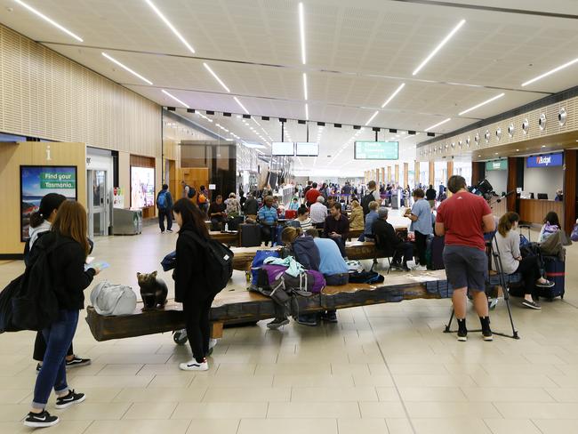 Every new arrival to Hobart Airport are being asked by Bio Security Tasmania to fill out forms advising authorities of travel details and contacts for passengers. Pictured are incoming passengers and the airport lounge. Also pictured is Prabesh Basnet, a cab driver who, with his work mates are left to play cards and smoke cigarette with many saying they are making around $9 per day wth monthly expenses of over $2126 - meaning a large nett loss due to Corona Virus / COVID-19.Picture: MATT THOMPSON