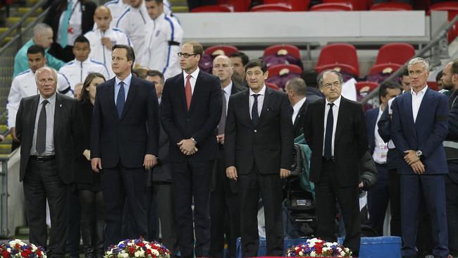 British Prime Minister David Cameron (2nd L), Britain's Prince William (3rd L) and France's coach Didier Deschamps (R) gather in front of floral tributes before the start of the friendly football match. Credit: AFP