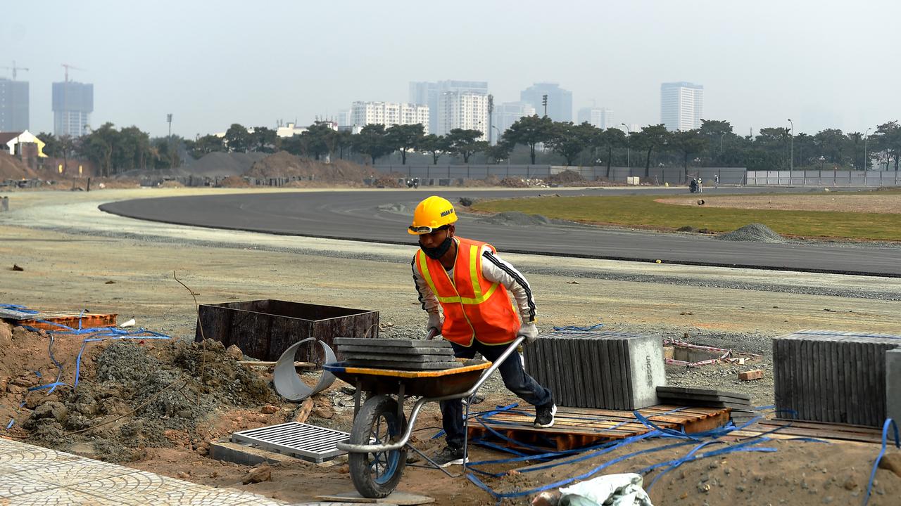 A construction worker pushes a wheel barrow at the track site in Hanoi on December 13.