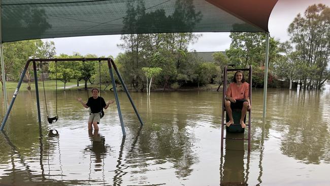 Jack Steele and Bailey Harasymenko on partially submerged playground equipment at Galeen Drive Park, Burleigh Waters. Picture: Laura Nelson