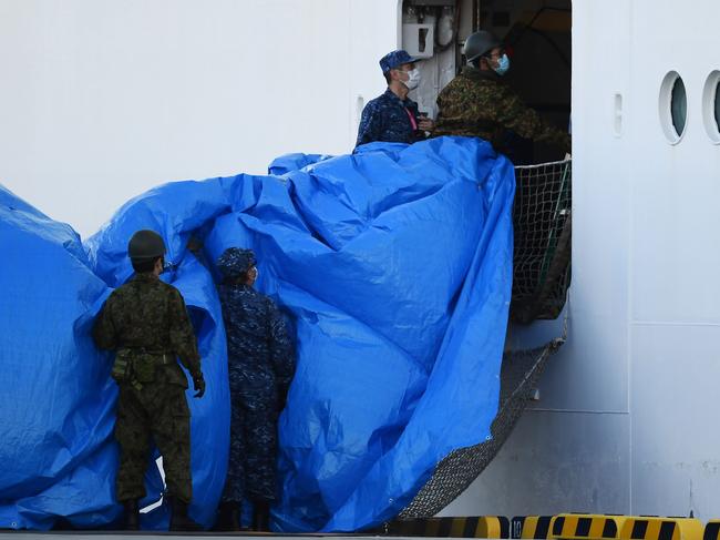 Military personnel set up a covered walkway next to the Diamond Princess. Picture: AFP