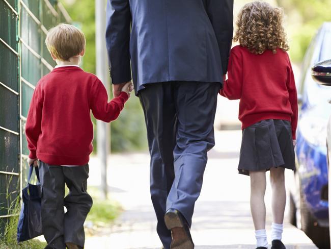 RendezView. Father Walking To School With Children On Way To Work. iStock.