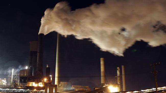 FILE - In this July 8, 2011 file photo, smoke bellows from a chimney stack at BlueScope Steel's steelworks at Port Kembla, south of Sydney, Australia. Prime Minister Tony Abbott reintroduced legislation to the Australian Parliament on Monday, June 23, 2014 that would repeal a carbon tax that the nation's worst greenhouse gas polluters have to pay. (AP Photo/Rob Griffith, File)