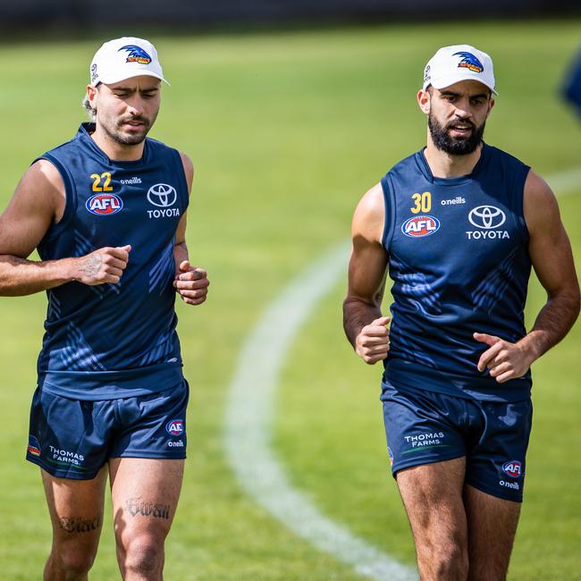 Izak Rankine and Wayne Milera run laps at training.