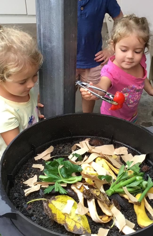 Mia and Mikayla Anderson feeding the worms in the Uniting Preschool Grafton worm farm.