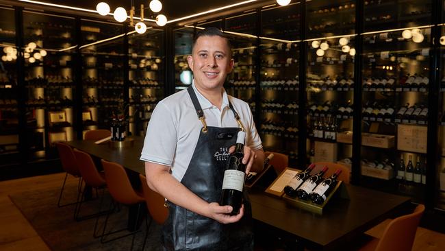 Store manager Walter Henao holds the $160,000 bottle of wine.