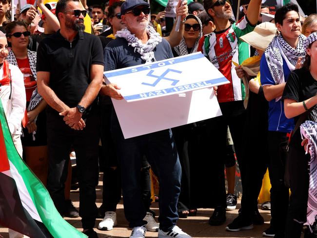 SYDNEY, AUSTRALIA - NewsWire Photos OCTOBER 6, 2024: A protester pictured holding  a flag that has a Nazi like symbol on it at the protest in Hyde Park. Protestors gather at Hyde Park in Sydney's CBD to demand an end to the ongoing war and Israel's current occupation of Gaza, and the escalating Israel-Lebanon conflict.Picture: NewsWire / Damian ShawAl Yazbek