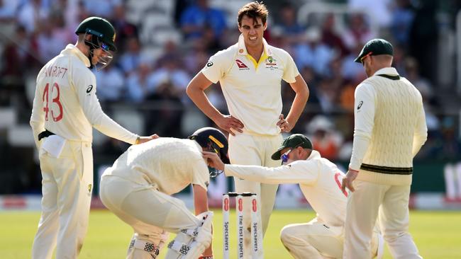 Australia's Cameron Bancroft and Pat Cummins check on England's Chris Woakes. Picture: AFP