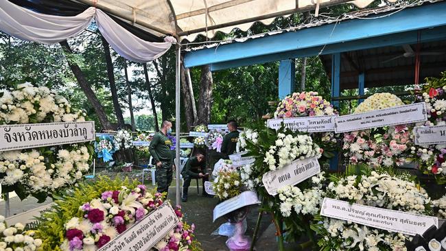 Thai Army soldiers gather next to wreaths prepared for the funerals of victims of the nursery mass shooting at Wat Si Uthai temple. Picture: AFP