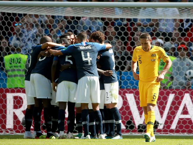 A dejected Mark Milligan walks away after the French celebrate the winning goal Picture: Toby Zerna