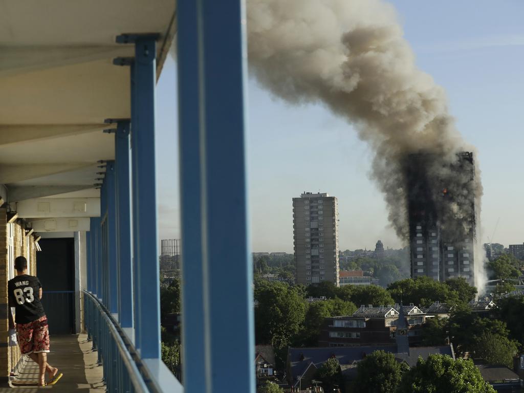 A resident in a nearby building watches smoke rise from the Grenfell Tower. Picture: AP Photo/Matt Dunham