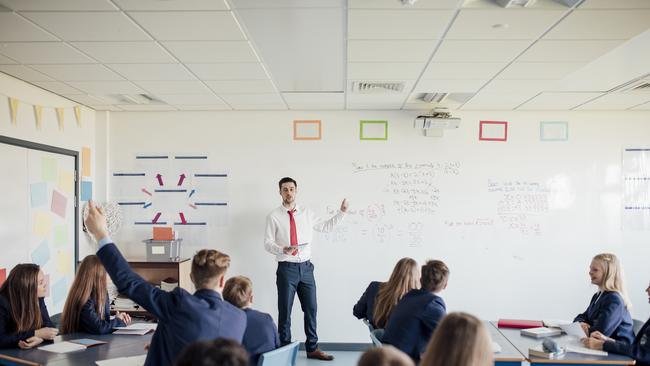 Teenage female student raising her hand to answer a question.