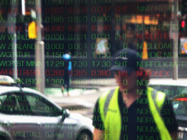 SYDNEY, AUSTRALIA - OCTOBER 18: Pedestrians are reflected in a window as electronic boards display stock information at the Australian Securities Exchange, operated by ASX Ltd., on October 18, 2022 in Sydney, Australia. Australia's Treasurer Jim Chalmers said last week that the country will not be immune from a darkening outlook for global inflation and interest rates, but that he expects Australia to be able to weather the turbulent economic headwinds better than most. (Photo by Lisa Maree Williams/Getty Images)