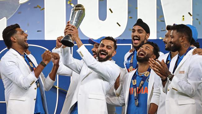 TOPSHOT - Indiaâs players celebrate with the trophy after winning the ICC Champions Trophy one-day international (ODI) final cricket match between India and New Zealand at the Dubai International Stadium in Dubai on March 9, 2025. (Photo by FADEL SENNA / AFP)