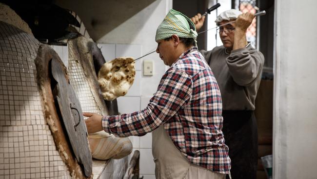 Zahir Haidari and Khadem Ali Afzali make bread at Lawash Bakery. Picture: Matt Turner.