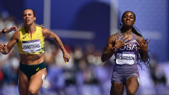 US' Sha'Carri Richardson (C) crosses the finish line to win past Australia's Bree Masters and Canada's Jacqueline Madogo in the women's 100m heat of the athletics event at the Paris 2024 Olympic Games at Stade de France in Saint-Denis, north of Paris, on August 2, 2024. (Photo by Jewel SAMAD / AFP)