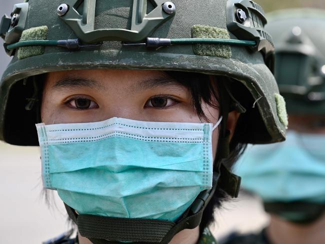 TOPSHOT - Female soldiers wearing face masks amid the COVID-19 coronavirus pandemic stand in formation during Taiwan President Tsai Ing-wen's visit to a military base in Tainan, southern Taiwan, on April 9, 2020. - Taiwan currently has just 375 confirmed Covid-19 patients and five deaths despite its close proximity and trade links with China where the pandemic began, but the island and its 23 million inhabitants remain locked out of the World Health Organisation (WHO) and other international bodies after Beijing ramped up its campaign to diplomatically isolate Taiwan and pressure it economically and militarily. (Photo by Sam Yeh / AFP)