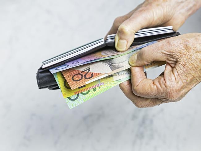 Payment: Close-up, senior female hands taking Australian banknotes (cash, currency) from purse containing many credit cards.  Horizontal, studio, copy space. Money generic