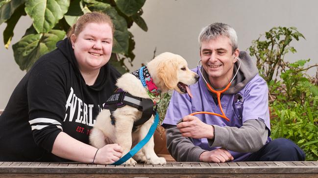 Maddie Powell with her dog, Miles, and vet Dr Chris McIver at Baptist Care in Adelaide. Picture: Matt Loxton