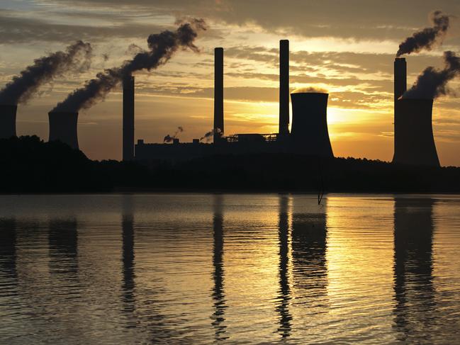 FILE - In this June 3, 2017, file photo, the coal-fired Plant Scherer, one of the nation's top carbon dioxide emitters, stands in the distance in Juliette, Ga. Since leaders first started talking about tackling the problem of climate change, the world has spewed more heat-trapping gases, gotten hotter and suffered hundreds of extreme weather disasters. Fires have burned, ice has melted and seas have grown. (AP Photo/Branden Camp, File)