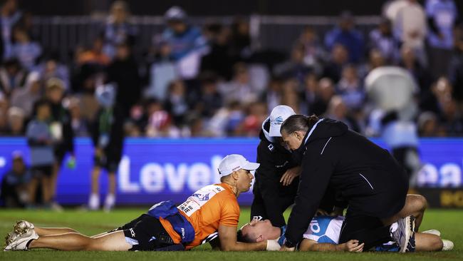 Connor Tracey of the Sharks receives assistance after being hit high in a tackle by Tariq Sims. Picture: Matt King/Getty Images