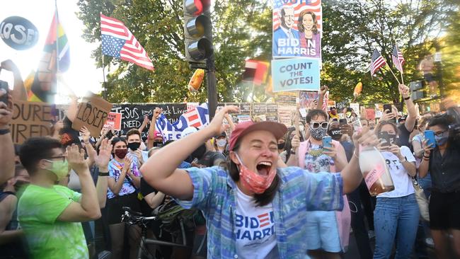 A woman dances after spraying prosecco onto the crowd as people celebrate on Black Lives Matter plaza across from the White House in Washington, DC on November 7. Picture: AFP