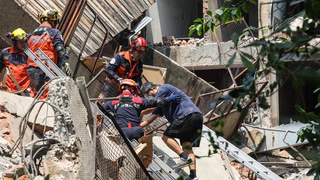 Emergency workers assisting a survivor after he was rescued from a damaged building in New Taipei City on Wednesday. Picture: AFP