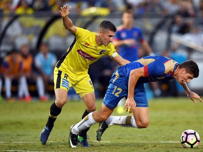 Harrison Sawyer (right) of the Jets is tackled by Nick Montgomery of the Mariners during the round 26 A-League match between the Central Coast Mariners and the Newcastle Jets at Central Coast Stadium in Gosford on Sunday, April 9, 2017. (AAP Image/Paul Miller) NO ARCHIVING, EDITORIAL USE ONLY