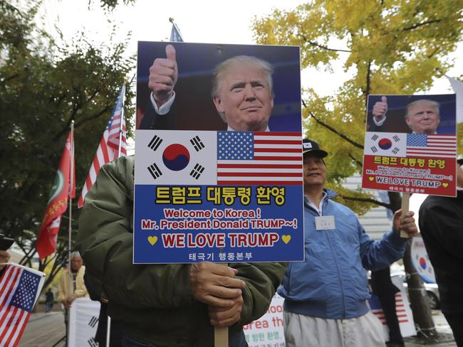 South Koreans hold banners with pictures of U.S. President Donald Trump during a rally welcoming his visit to the country in downtown Seoul, South Korea. Picture: AP